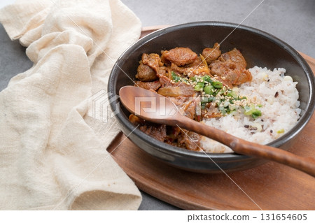 Jeyukdeopbap, Korean Food Spicy Stir-fried Pork with Rice in Black Bowl Jeyukdeopbap, Korean Food Spicy Stir-fried Pork with Rice in Black Bowl 131654605