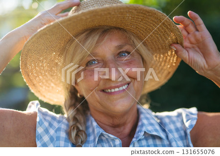 Happy elderly woman enjoying sunny day in garden. Happy elderly woman enjoying sunny day in garden. 131655076