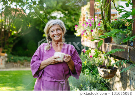 Quiet morning in garden for older woman. Self ritual with coffee. Quiet morning in garden for older woman. Self ritual with coffee. 131655098