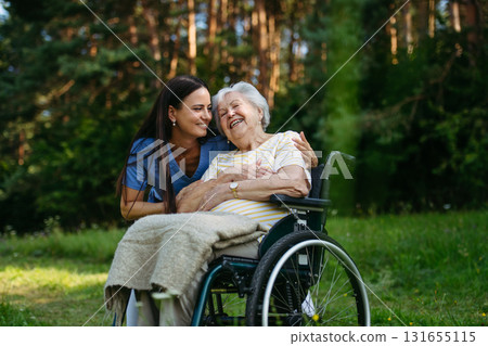 Home nurse taking care of elderly woman in wheelchair. 131655115