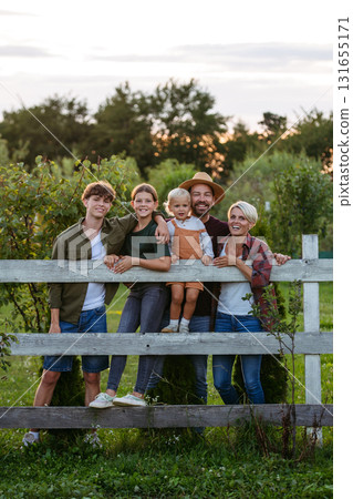 Farmer family portrait. Prents with three kids. 131655171