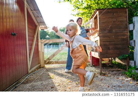 Little boy playing on farm, running around in chicken run. 131655175