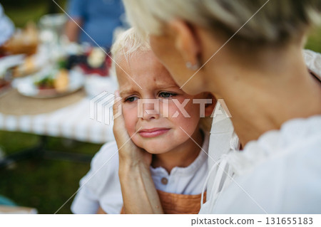 Mom trying to calm down crying toddler boy. 131655183