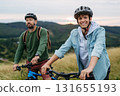 Dad and teen boy riding bicycles in mountains. Cycling trip during autumn day. 131655193