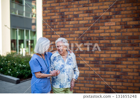 Home caregiver taking old patient for walk in the city. Home caregiver taking old patient for walk in the city. 131655248