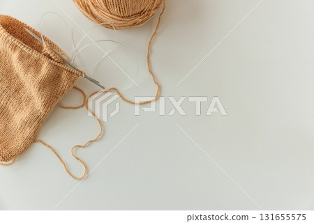 Circular Knitting Project with Tan Yarn and Needles on White Table Circular Knitting Project with Tan Yarn and Needles on White Table 131655575