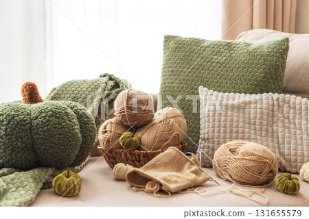 Knitting Basket with Yarn and Velvet Pumpkins in Cozy Autumn Sofa Knitting Basket with Yarn and Velvet Pumpkins in Cozy Autumn Sofa 131655579