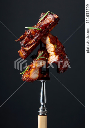 Grilled pork belly with rosemary on a fork. Grilled pork belly with rosemary on a fork. 131655799