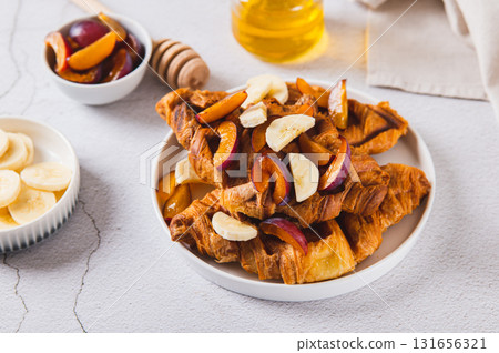 Waffle croissants with fruits, berries and honey on a plate on the table 131656321