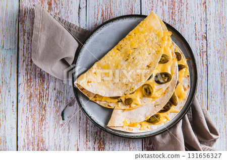 Close up of spicy quesadilla with cheese and jalapeno pepper on a plate on the table top view 131656327