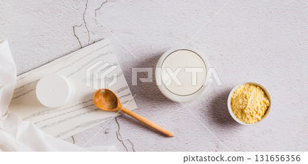 Bovine colostrum powder in a bowl and diluted drink in a glass on a table top view web banner Bovine colostrum powder in a bowl and diluted drink in a glass on a table top view web banner 131656356