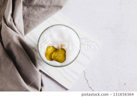 Close up of latte with pickles in a glass and pickles in a bowl on the table top view Close up of latte with pickles in a glass and pickles in a bowl on the table top view 131656364