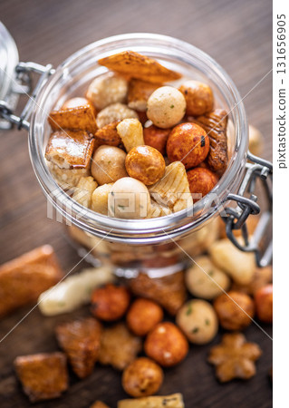 Salted snack. Coated peanuts and mini crackers on wooden table. Salted snack. Coated peanuts and mini crackers on wooden table. 131656905