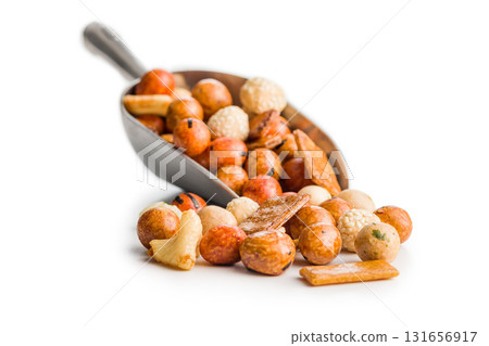 Salted snack. Coated peanuts and mini crackers on scoop isolated on white background. Salted snack. Coated peanuts and mini crackers on scoop isolated on white background. 131656917