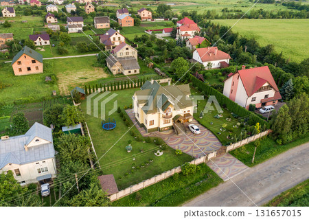 Aerial landscape of small town or village with rows of residential homes and green trees. 131657015