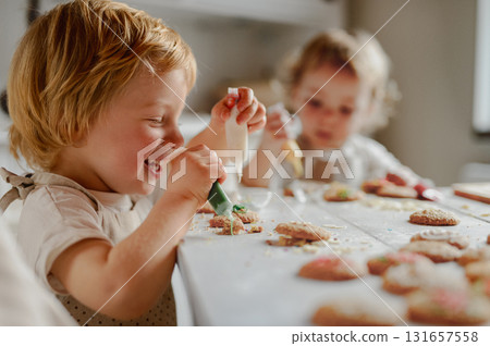 Happy children decorating Christmas cookies at home. 131657558