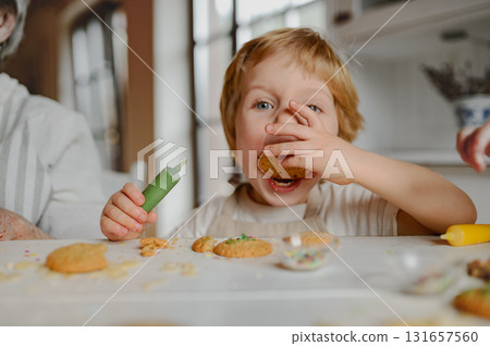 Happy children decorating Christmas cookies at home. 131657560