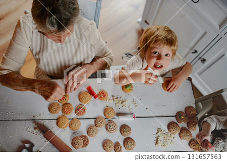 Family holiday baking with grandma in cozy kitchen. Family holiday baking with grandma in cozy kitchen. 131657563