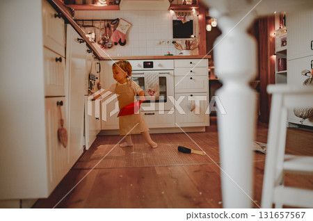 Little girl cleaning up flour mess in kitchen. 131657567