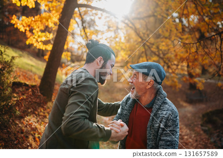 Grandad and grandson hugging in the middle of autumn park. Grandad and grandson hugging in the middle of autumn park. 131657589