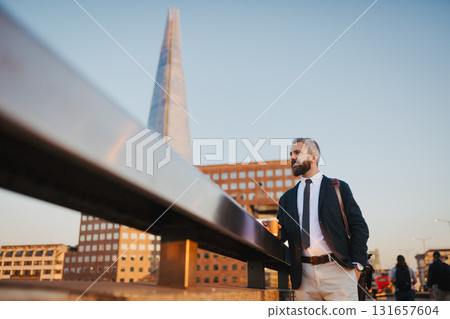 Mature businessman standing on bridge in the city. Mature businessman standing on bridge in the city. 131657604
