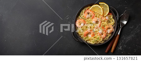 Delicious seafood pasta spaghetti with shrimps dish garnished with lemon and parsley top view on black background, space for text 131657821