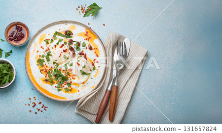 Turkish eggs cilbir, Middle Eastern style breakfast on blue background table top view, space for text 131657824