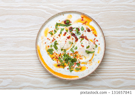 Turkish eggs cilbir, Middle Eastern style breakfast on white wooden background table top view 131657841