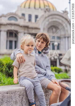 Two young boy tourists in front of Palacio de Bellas Artes in Mexico City, enjoying sightseeing, travel adventure, and cultural exploration. Childhood travel and tourism concept 131657988