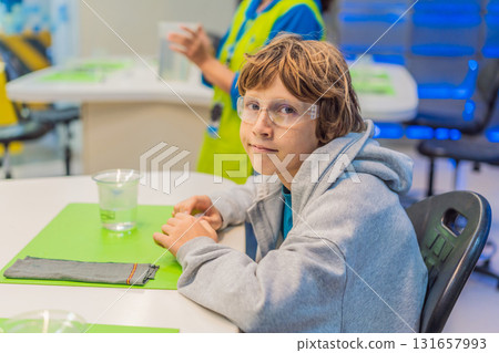 Teenage boy wearing safety glasses prepares to conduct chemistry experiments, representing STEM education, curiosity, and the excitement of hands-on scientific discovery Teenage boy wearing safety glasses prepares to conduct chemistry experiments, representing STEM education, curiosity, and the excitement of hands-on scientific discovery 131657993