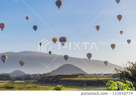 Colorful hot air balloons floating over Teotihuacan in Mexico, creating a breathtaking view of the ancient pyramids. Tourism, adventure, and cultural heritage concept Colorful hot air balloons floating over Teotihuacan in Mexico, creating a breathtaking view of the ancient pyramids. Tourism, adventure, and cultural heritage concept 131658774