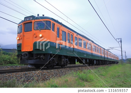 Shinano Railway 115 series train (Shonan color) running through Karuizawa on a cloudy day _ Photographed on October 4, 2025 Shinano Railway 115 series train (Shonan color) running through Karuizawa on a cloudy day _ Photographed on October 4, 2025 131659357