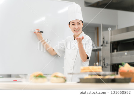 A female instructor who teaches at cooking seminars, vocational schools, and employee training 131660892