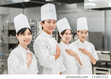 Chefs and cooks in chef coats standing in the kitchen 131661312
