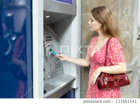 Young woman using card at atm 131661541
