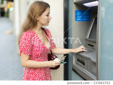 Young woman withdrawing a day from an atm 131661552