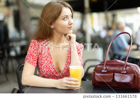 Young woman drinking juice 131661578