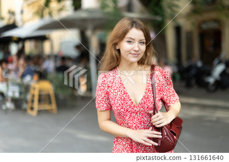 Woman in dress looking around city street on summer day 131661640