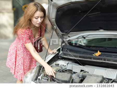 Young woman is worried about her car breaking down on city street 131661643