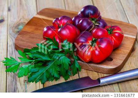 Beefsteak tomatoes and parsley on wooden table 131661677
