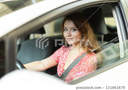 Woman driving in car, buckled up 131661679