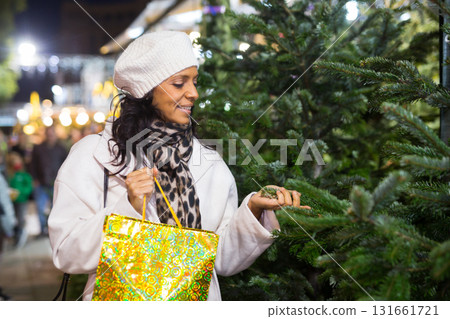 Portrait of a Latin American woman choosing a Christmas tree 131661721