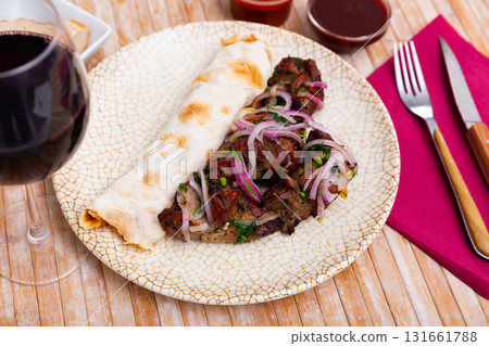 Grilled pork meat shashlik with sliced onion 131661788