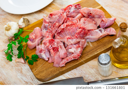 Raw sliced rabbit lying on wooden cutting board with seasonings Raw sliced rabbit lying on wooden cutting board with seasonings 131661801