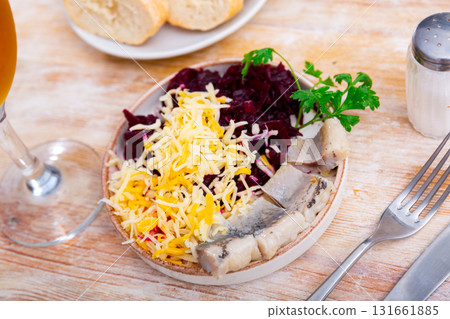 Pieces of chopped herring with beet and cheese served on plate 131661885