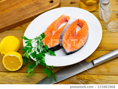 Salmon slice on plate with garlic, herbs and lemon Salmon slice on plate with garlic, herbs and lemon 131661908
