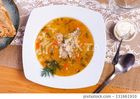 National Russian dish is Pickle soup with meat, cooked on basis of pickled cucumbers and pearl barley 131661910