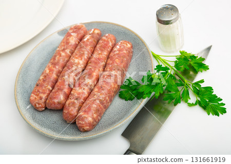 Tasty spiced butifarra, pork sausage with mushrooms with herbs on plate 131661919