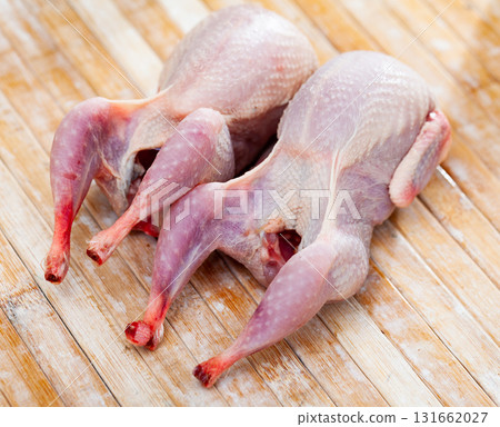 Two gutted quails prepared for cooking on wooden table Two gutted quails prepared for cooking on wooden table 131662027