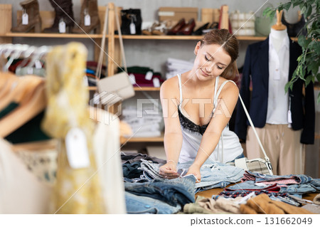 Woman shopping in clothing department, buying denim pantalones 131662049